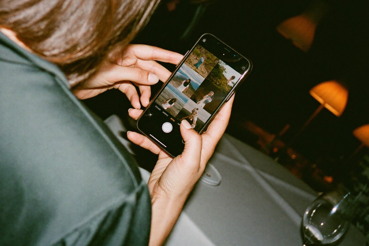 Vendég a saját telefonján a bulin készült fotóval